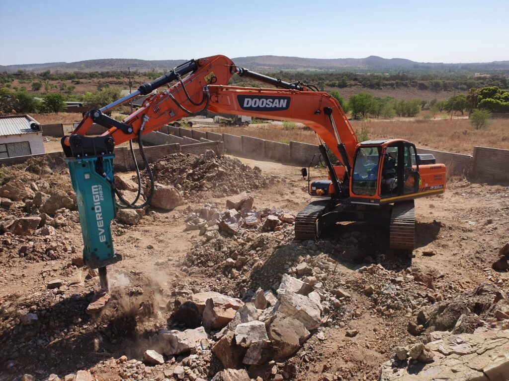 Doosan excavator fitted with a hydraulic breaker performing rock breaking and excavation as part of Plant Pro's heavy equipment and plant hire fleet in South Africa.